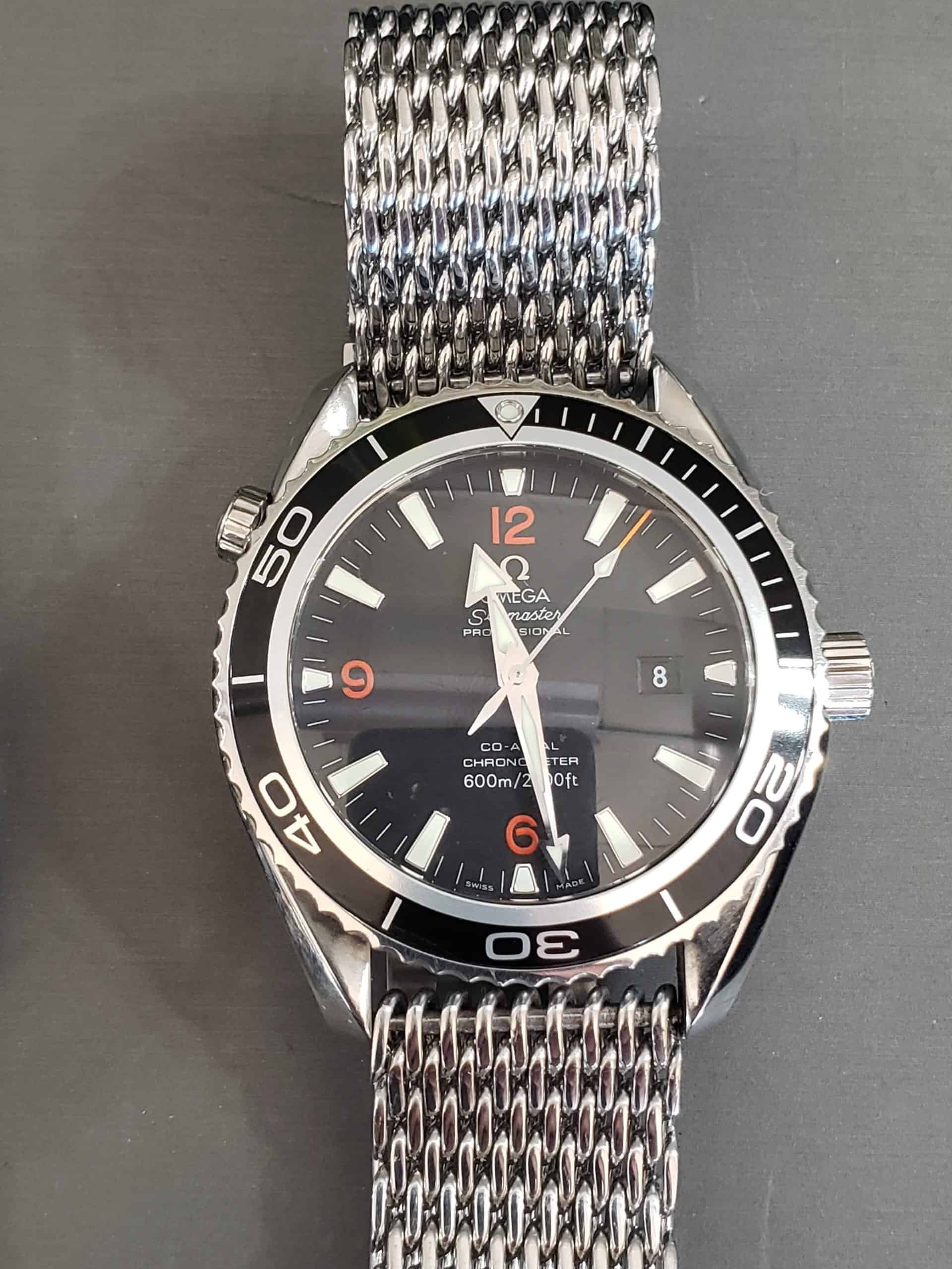Omega Seamaster Planet Ocean 600m with black dial, orange numerals and mesh bracelet